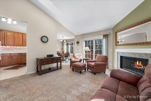 living area featuring light carpet, a warm lit fireplace, an inviting chandelier, high vaulted ceiling, and light tile patterned flooring