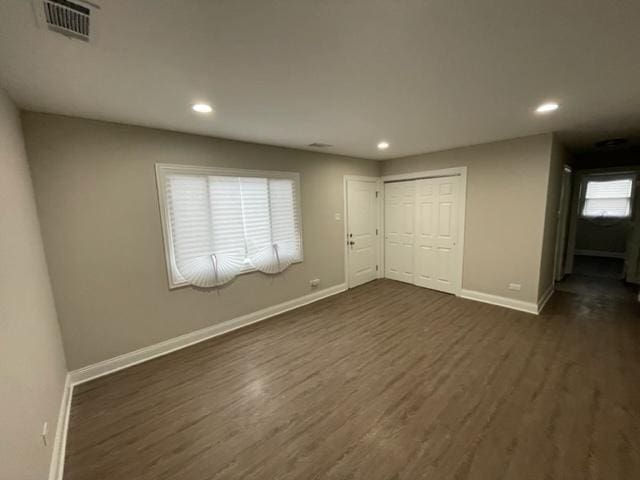 empty room with visible vents, baseboards, dark wood-style flooring, and recessed lighting