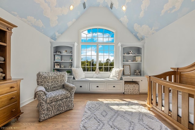 bedroom featuring light wood finished floors, visible vents, and high vaulted ceiling