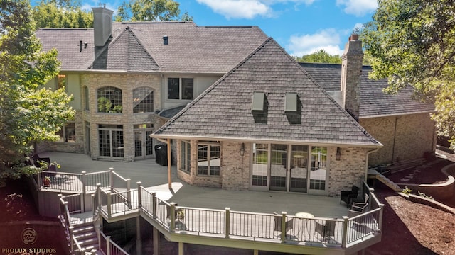 rear view of property with a wooden deck and a chimney