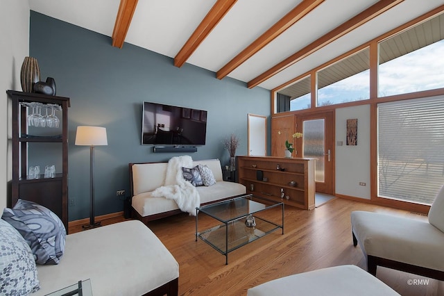 living room featuring baseboards, wood finished floors, and vaulted ceiling with beams