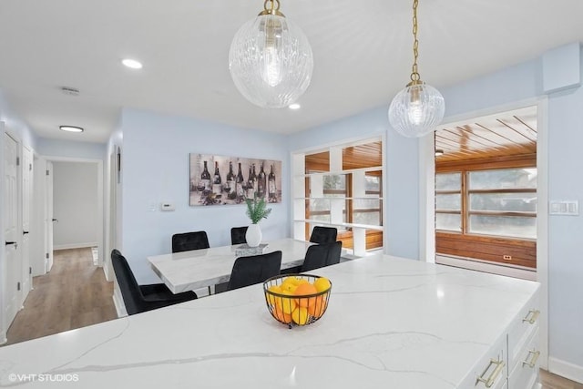 dining space with baseboards, light wood-style flooring, and recessed lighting