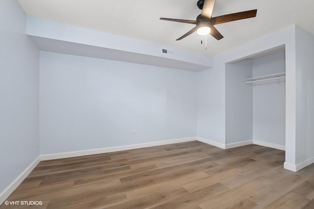 unfurnished bedroom with baseboards, visible vents, a ceiling fan, wood finished floors, and a closet