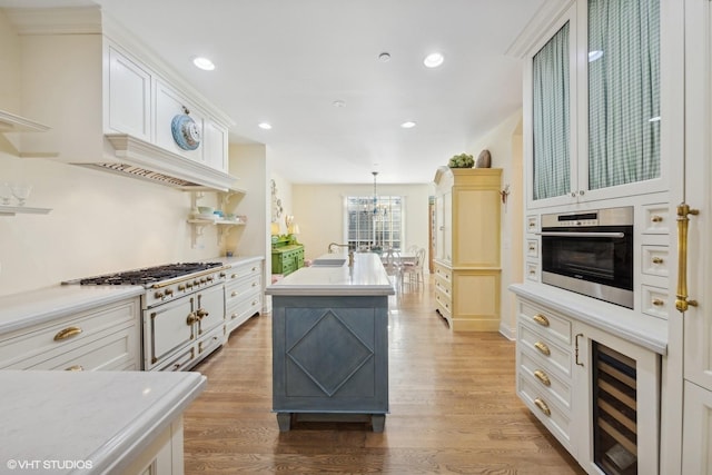 kitchen with stainless steel oven, beverage cooler, light countertops, and light wood finished floors