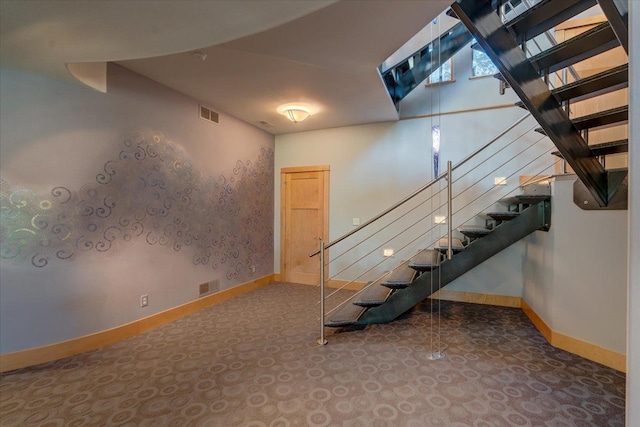 basement with baseboards, stairs, and visible vents