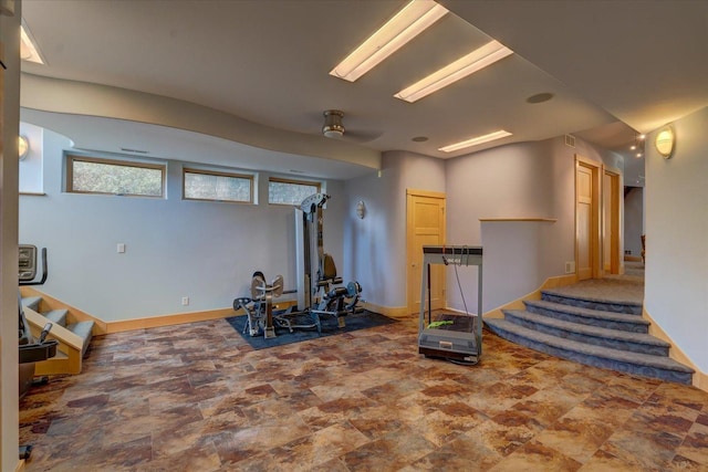 workout area featuring stone finish flooring and baseboards