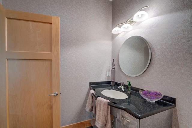 bathroom featuring a textured wall and vanity