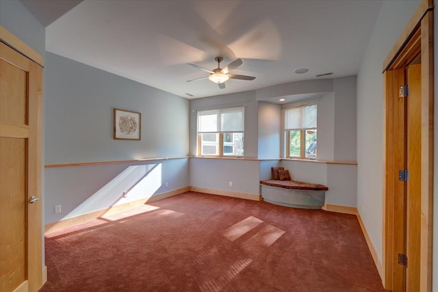 unfurnished room with carpet flooring, ceiling fan, visible vents, and baseboards