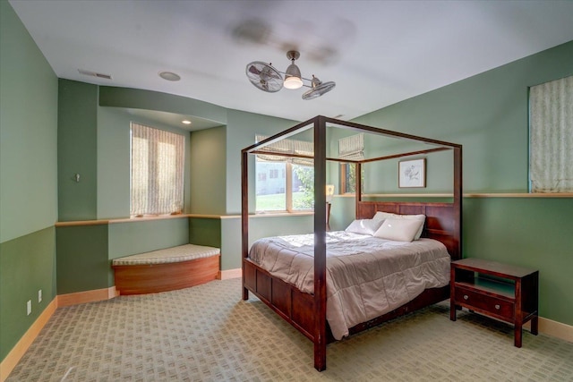 bedroom with light colored carpet, visible vents, baseboards, and multiple windows