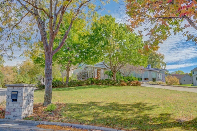 obstructed view of property with a front yard