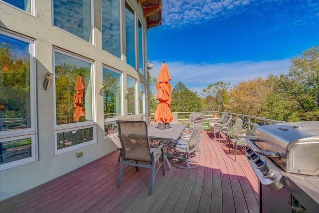 deck featuring outdoor dining area and a grill