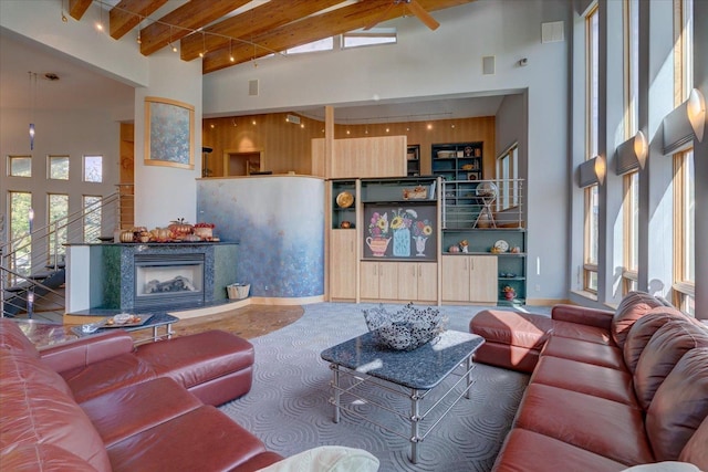 living area with a wealth of natural light, beam ceiling, and a towering ceiling