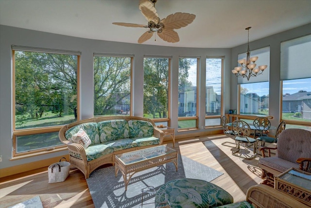 sunroom with ceiling fan with notable chandelier