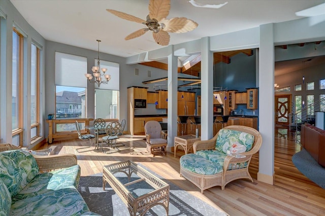 sunroom with a sink and ceiling fan with notable chandelier