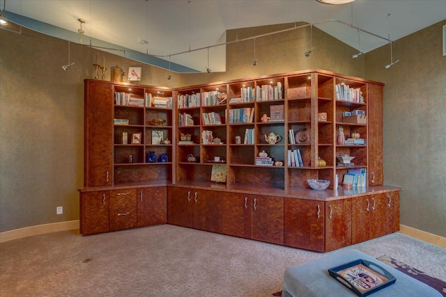 office area with light carpet, a towering ceiling, and baseboards