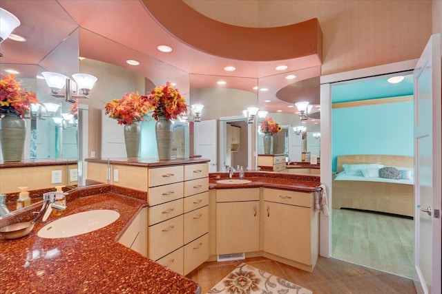 full bathroom with two vanities, a sink, and ensuite bath