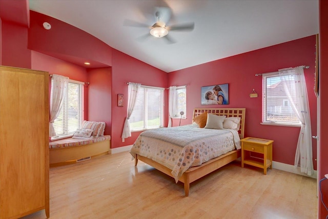 bedroom with lofted ceiling, light wood-style flooring, and multiple windows