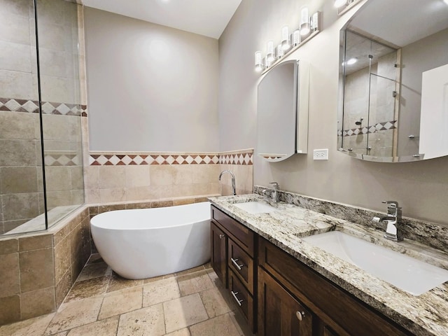 bathroom featuring a soaking tub, a sink, a tile shower, and stone tile floors