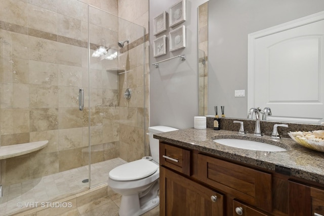 full bath featuring a stall shower, vanity, toilet, and tile patterned floors