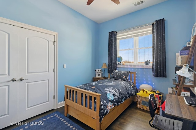 bedroom with ceiling fan, dark wood-type flooring, visible vents, and baseboards