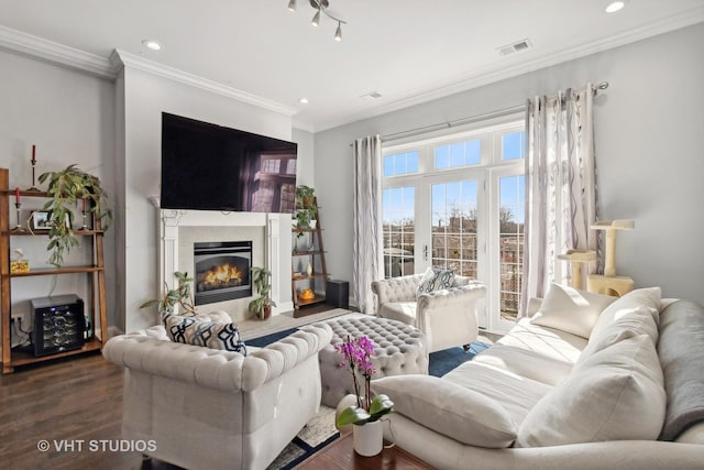 living room featuring recessed lighting, wood finished floors, a high end fireplace, visible vents, and ornamental molding