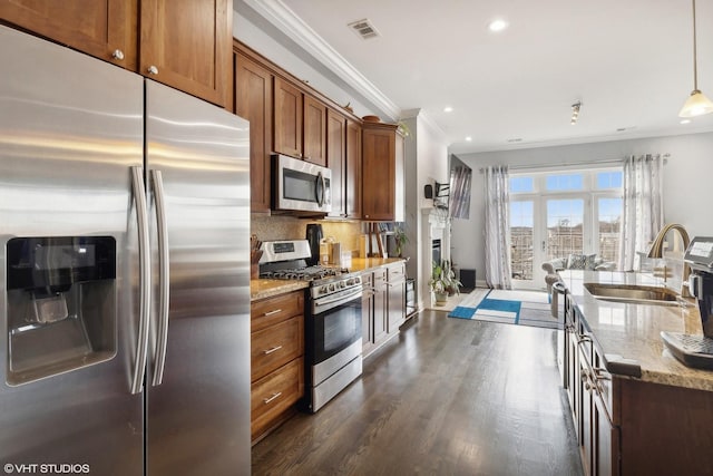 kitchen with visible vents, light stone counters, appliances with stainless steel finishes, pendant lighting, and a sink