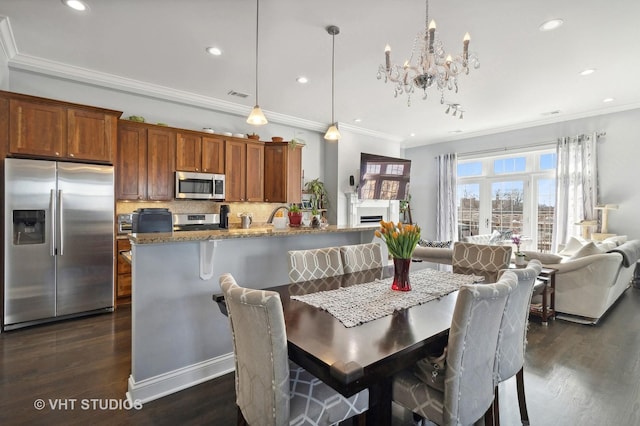 dining area featuring dark wood-style flooring, a fireplace, recessed lighting, visible vents, and ornamental molding