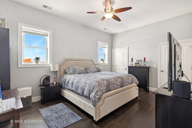 bedroom featuring ceiling fan, dark wood-type flooring, visible vents, and baseboards