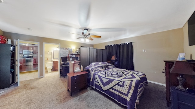 bedroom featuring a ceiling fan, light colored carpet, baseboards, and ensuite bathroom