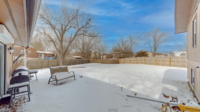 snow covered patio featuring a fenced backyard