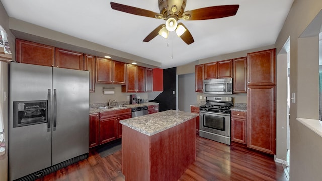 kitchen with stainless steel appliances, a sink, a kitchen island, a ceiling fan, and dark wood-style floors