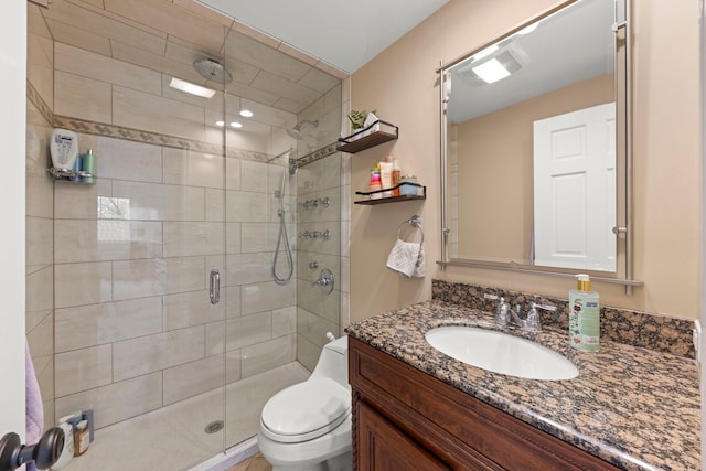 bathroom featuring vanity, a stall shower, and toilet