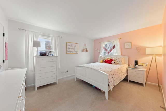 bedroom with light colored carpet, baseboards, and multiple windows