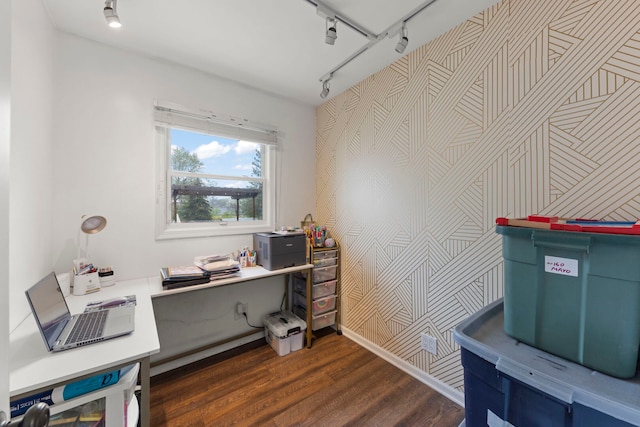 office featuring track lighting, an accent wall, wallpapered walls, and dark wood-style floors