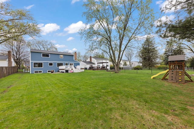 view of yard featuring a playground, fence, and a deck