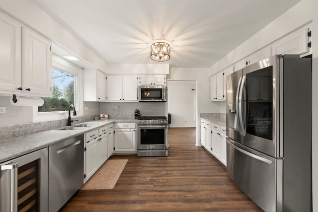 kitchen featuring a sink, light countertops, beverage cooler, stainless steel appliances, and dark wood-type flooring