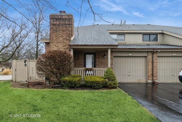 view of front of property featuring roof with shingles, aphalt driveway, a front lawn, and a chimney