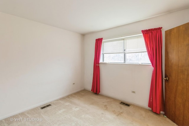 empty room with visible vents and light colored carpet