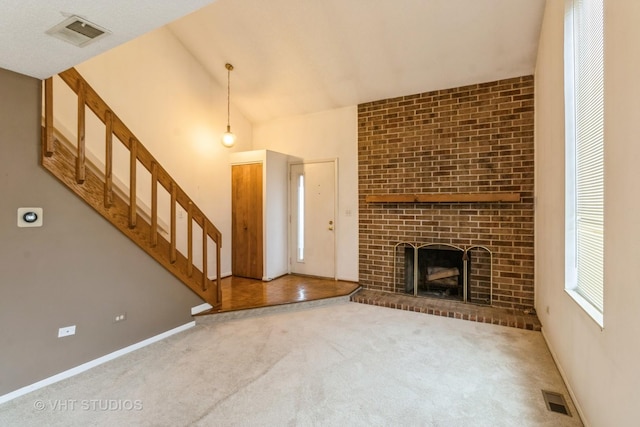 unfurnished living room with stairs, a fireplace, carpet flooring, and visible vents