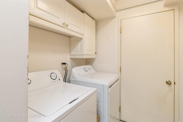 clothes washing area featuring cabinet space and separate washer and dryer