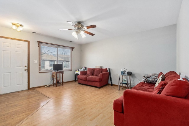 living room featuring light wood-style floors, visible vents, ceiling fan, and baseboards