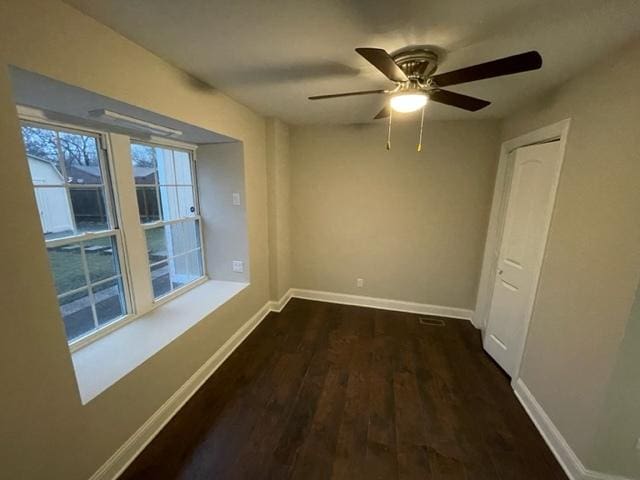 empty room with a ceiling fan, baseboards, and wood finished floors