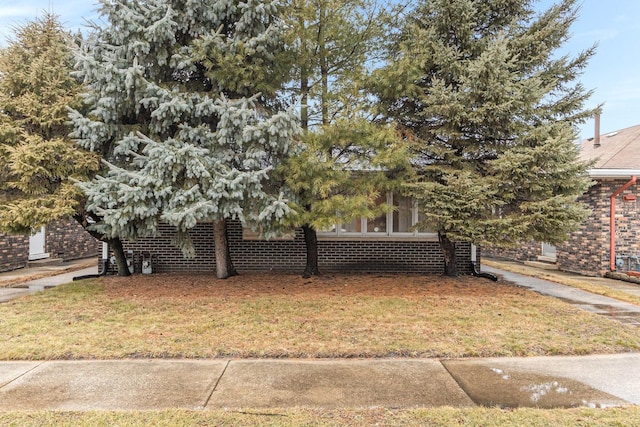 view of front facade featuring a front yard and brick siding