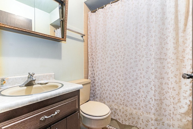 bathroom with toilet, curtained shower, and vanity