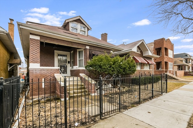 view of front of property featuring a fenced front yard, brick siding, and a porch