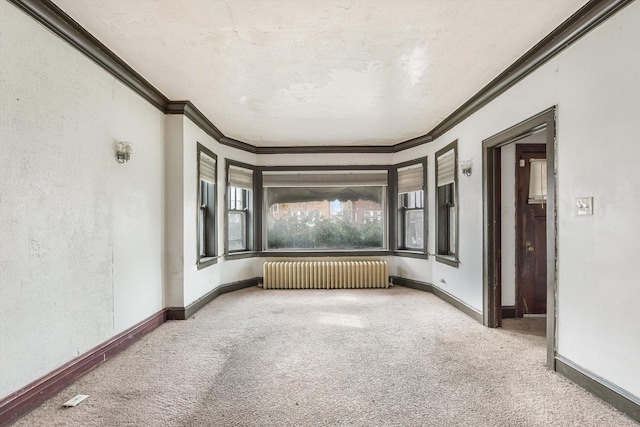 unfurnished room with carpet, radiator heating unit, ornamental molding, and baseboards