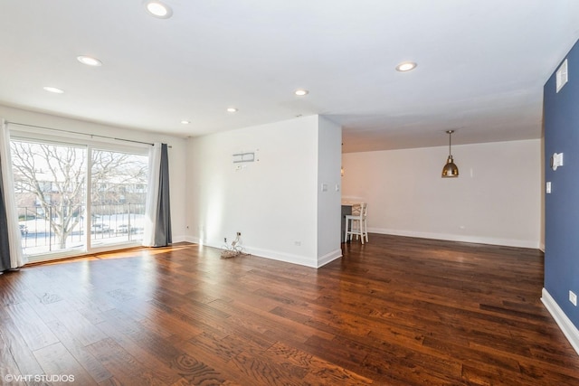 unfurnished living room with baseboards, dark wood finished floors, and recessed lighting