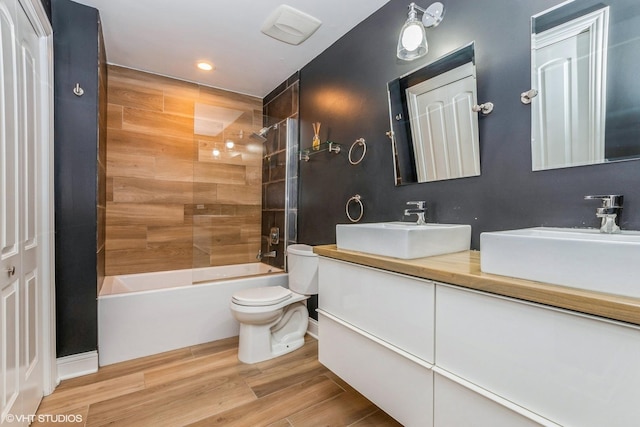 bathroom featuring  shower combination, a sink, toilet, and wood finished floors