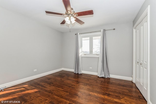 unfurnished bedroom with ceiling fan, a closet, baseboards, and dark wood-style flooring