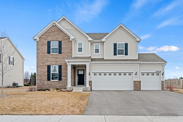 view of front of house featuring roof with shingles, brick siding, central AC unit, fence, and driveway